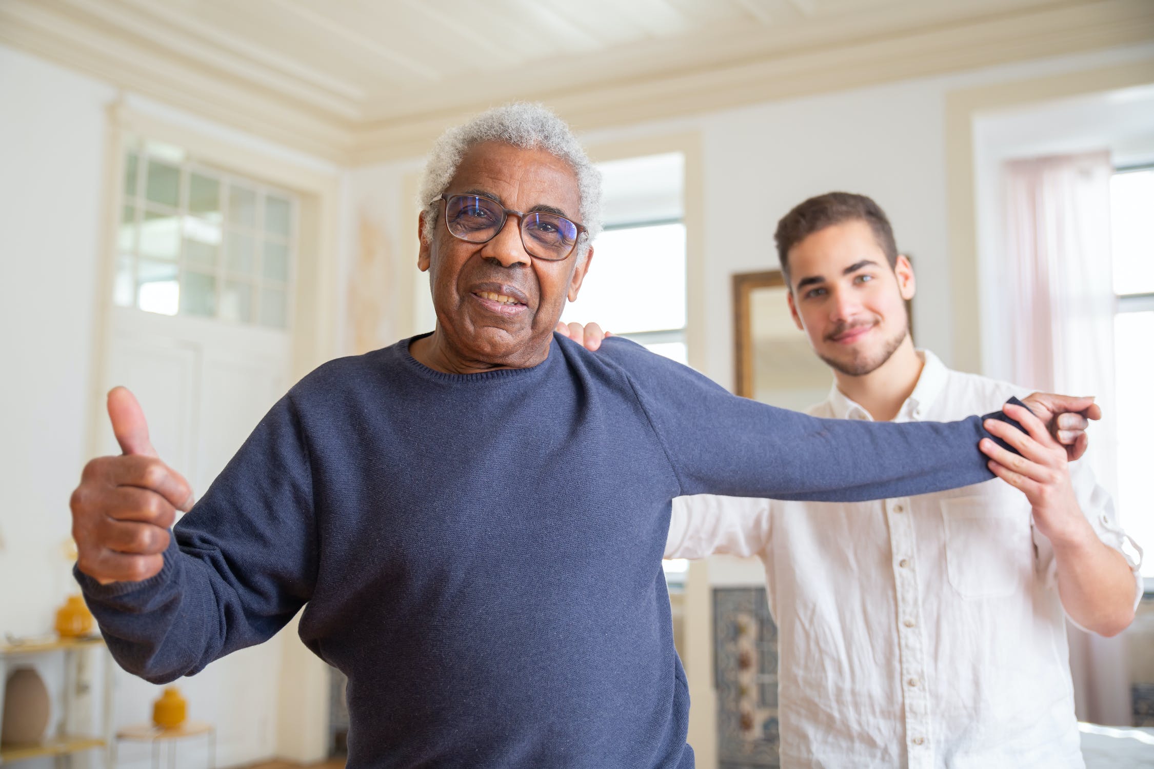 Image of support worker similing with client and having their thumbs up